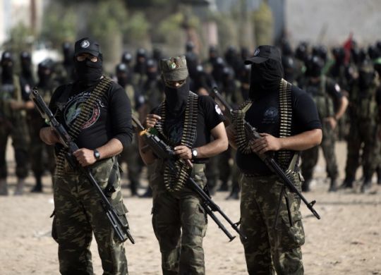 Palestinian militants of the Ezzedine al-Qassam Brigades, Hamas's armed wing, stage an anti-Israel parade as part of the celebrations marking the first anniversary of an Israeli army operation in the Gaza Strip, on November 14, 2013. A year after trading fire in a week-long war in Gaza, in which more than 170 Palestinians and six Israelis were killed, Israel and Hamas are squaring up for another confrontation, despite both sides appearing reluctant to make the first move . AFP PHOTO / MAHMUD HAMS