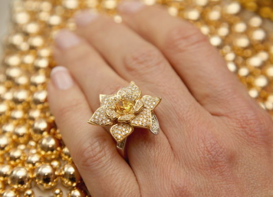 LONDON, ENGLAND - MAY 15: Heather Kerzner poses wearing the George Pragnell Daffodil Ring set with a rare oval fancy vivid orange/yellow diamond donated by jeweller George Pragnell and designed in recognition of Marie Curie's symbolic daffodil, during the Marie Curie Cancer Care Fundraiser hosted by Heather Kerzner at Claridge's Hotel on May 15, 2012 in London, England. The ring was auctioned as part of the Marie Curie Cancer care fundraising dinner. Marie Curie Nurses provide free end of life care to patients with terminal illness in their own homes or in one of their nine hospices. (Photo by Chris Jackson/Getty Images for Marie Curie Cancer Care)