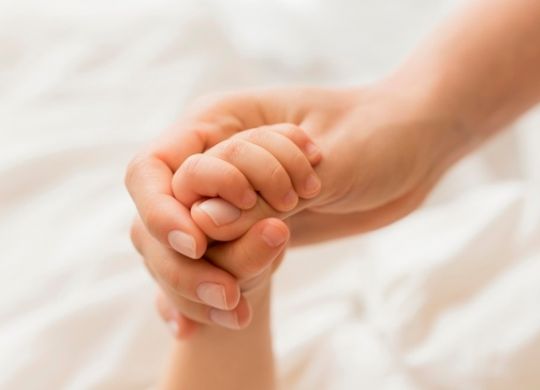 close-up-mom-and-baby-holding-hands_23-2148552549
