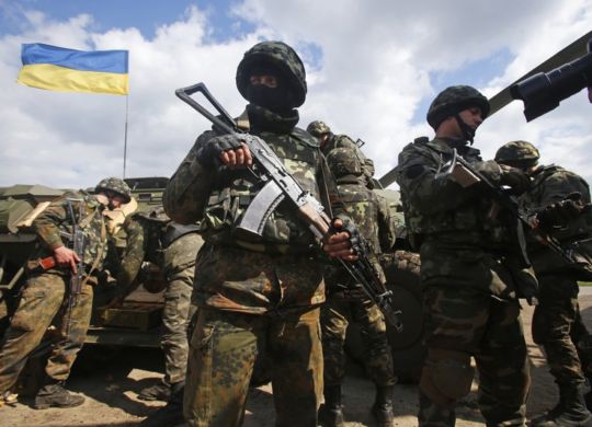 Ukrainian Army troops receive munitions at a field on the outskirts of Izyum, Eastern Ukraine, Tuesday, April 15, 2014. An Associated Press reporter saw at least 14 armored personnel carriers with Ukrainian flags, one helicopter and military trucks parked 40 kilometers (24 miles) north of the city on Tuesday. (AP Photo/Sergei Grits)