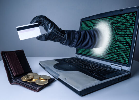 The abstract image of the hacker's hand reach through a laptop screen for stealing credit card in a wallet. the concept of cyber attack, virus, malware, illegally and cyber security.